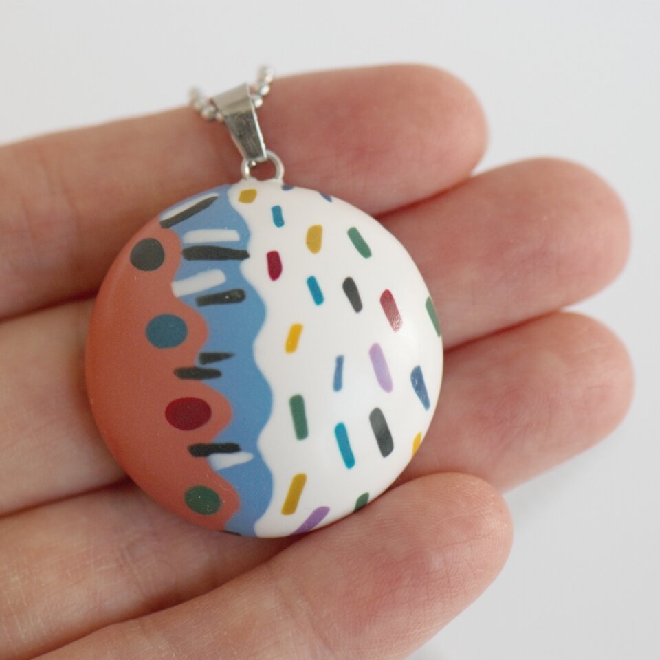 Apvalus rankų darbo pakabukas su spalvotu ornamentu