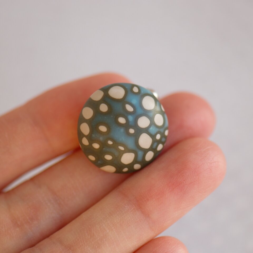 Apvali, taškuota rankų darbo sagė