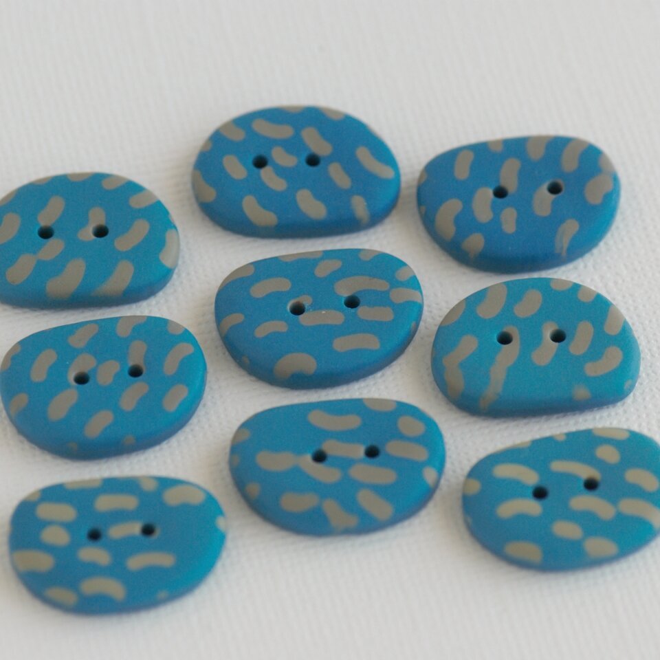 22 mm - 16 mm – 9 vnt. turkio mėlynos spalvos pailgos, akmenėlių formos sagos